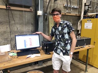 Illinois undergraduate student Mason Housenga demonstrates the quality-assurance data base, which logs more than 100 quantities for each EMCal block. Photo submitted.&nbsp;