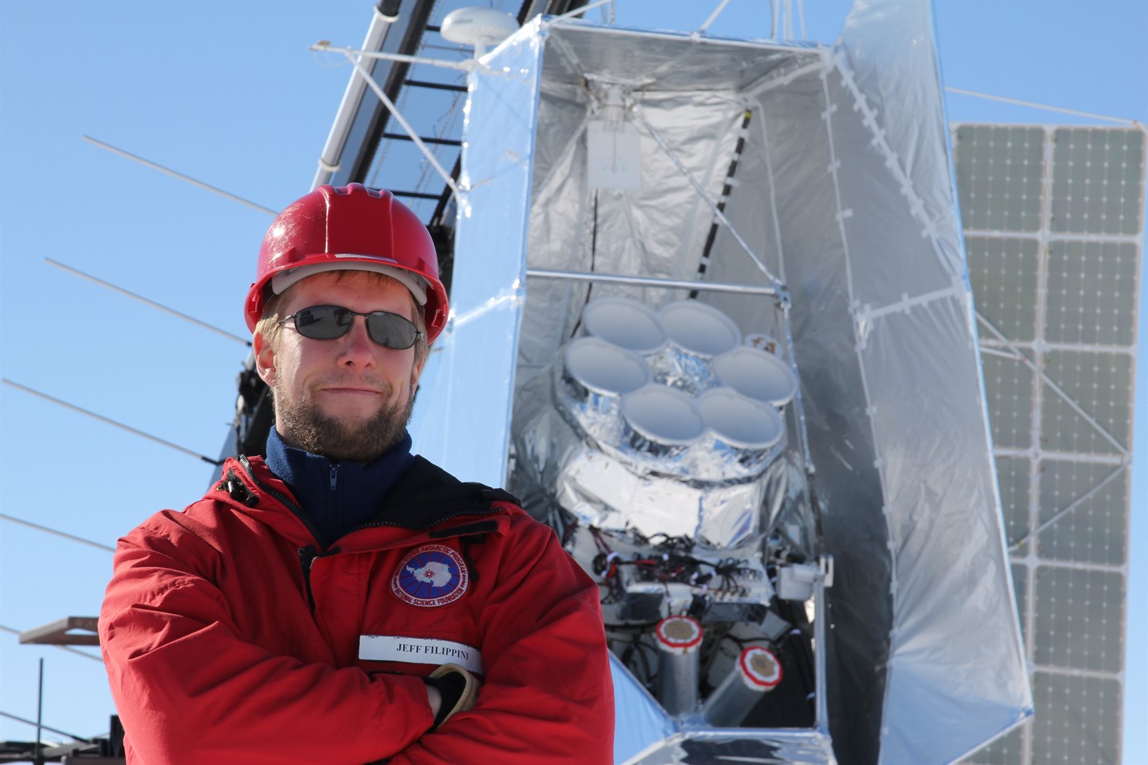 <sub>Illinois Physics Professor Jeff Filippini stands in front of SPIDER, a balloon-borne cosmic microwave background (CMB) telescope, on the launch pad at McMurdo Station, Antarctica. SPIDER is a cryogenic payload filled with over 1,000 liters of liquid helium. Credit: SPIDER Collaboration</sub>