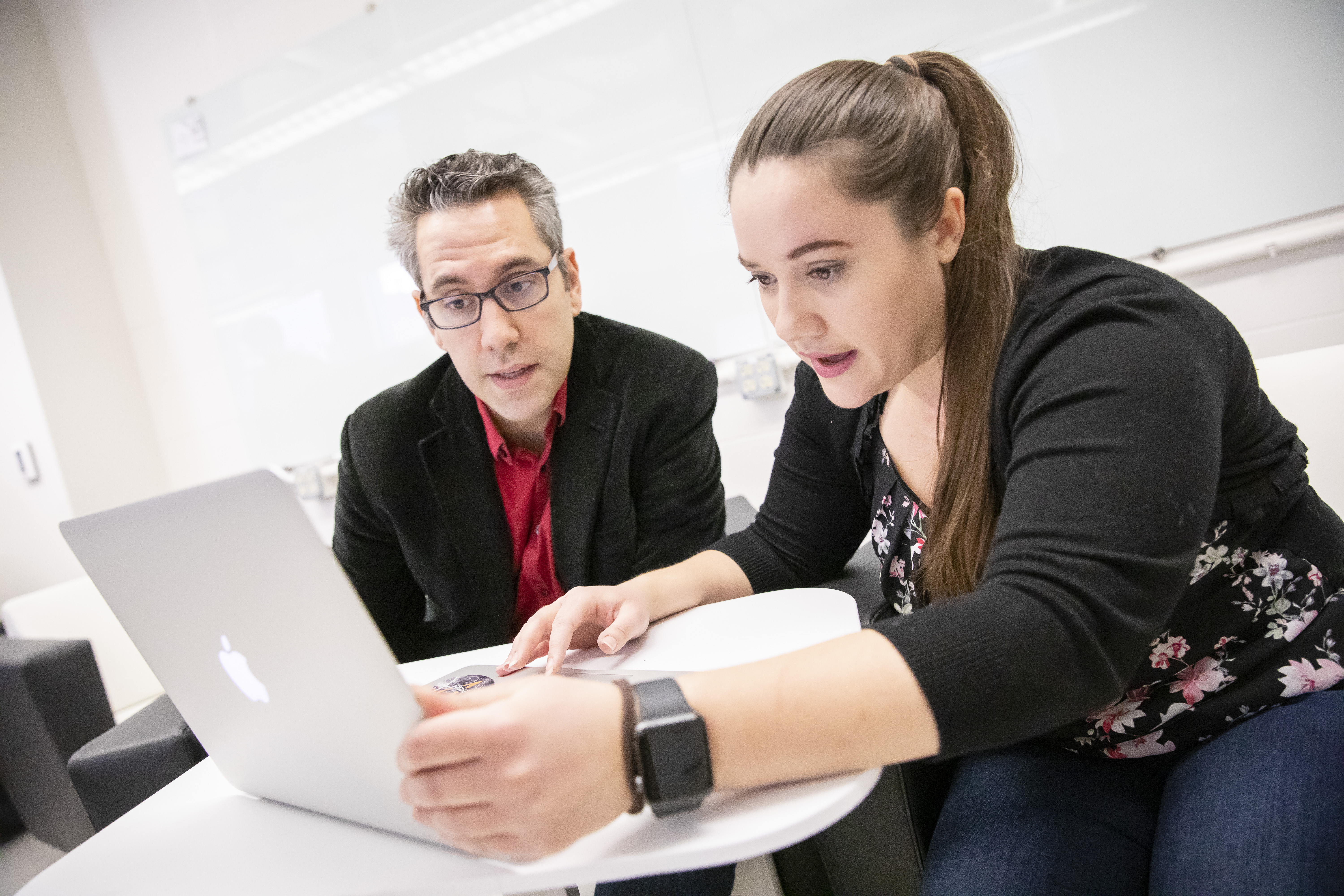 Professor Nico Yunes discusses a matter with Kristen Schumacher in front of a laptop.