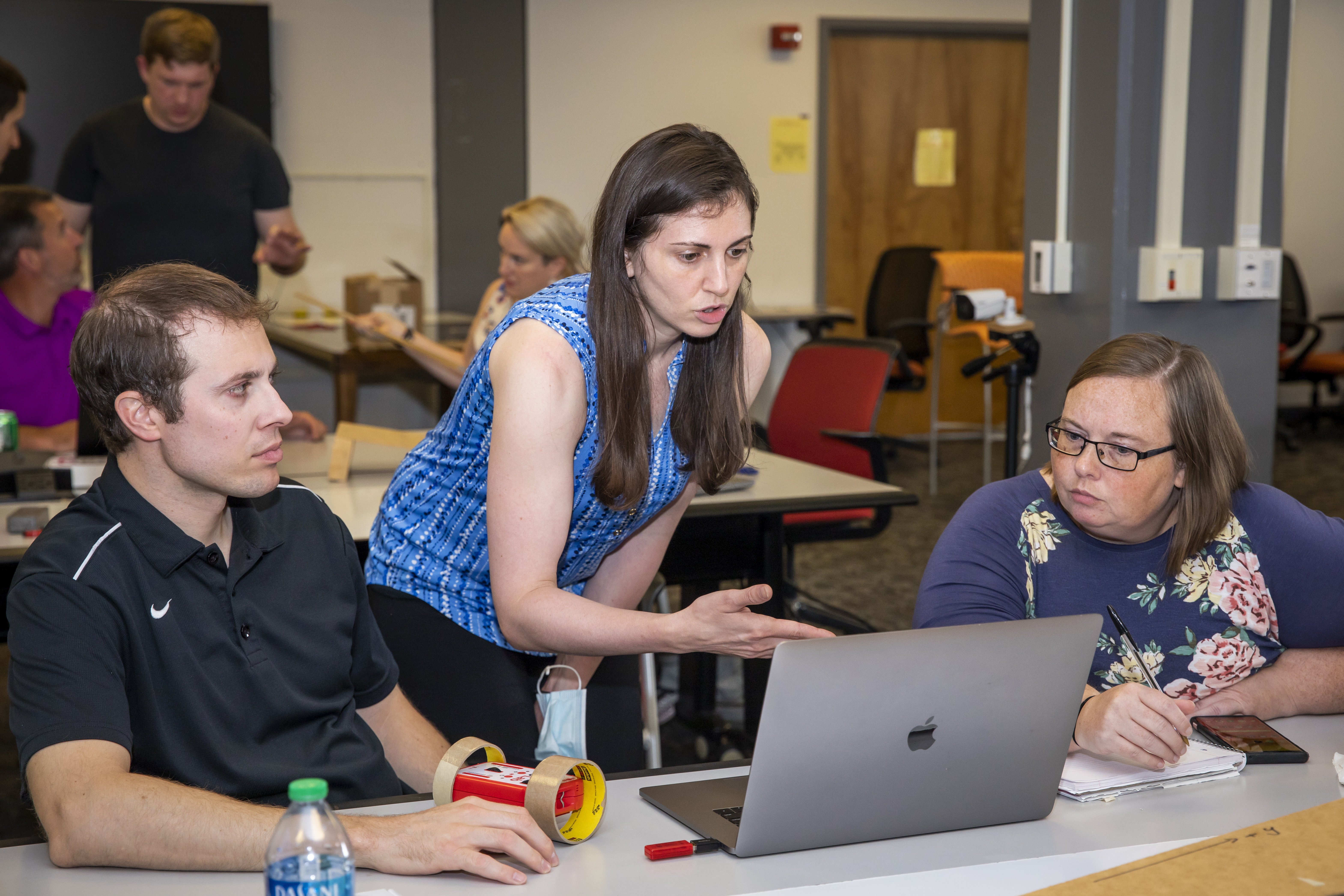 IPaSS coordinator Maggie Mahmood (middle) and IPaSS teaching fellows Brendan Aydt (left) and Cassy Baker interpret data represented on an iOLab graph. Photo by Michelle Hassel, University of Illinois Urana-Champaign&nbsp;