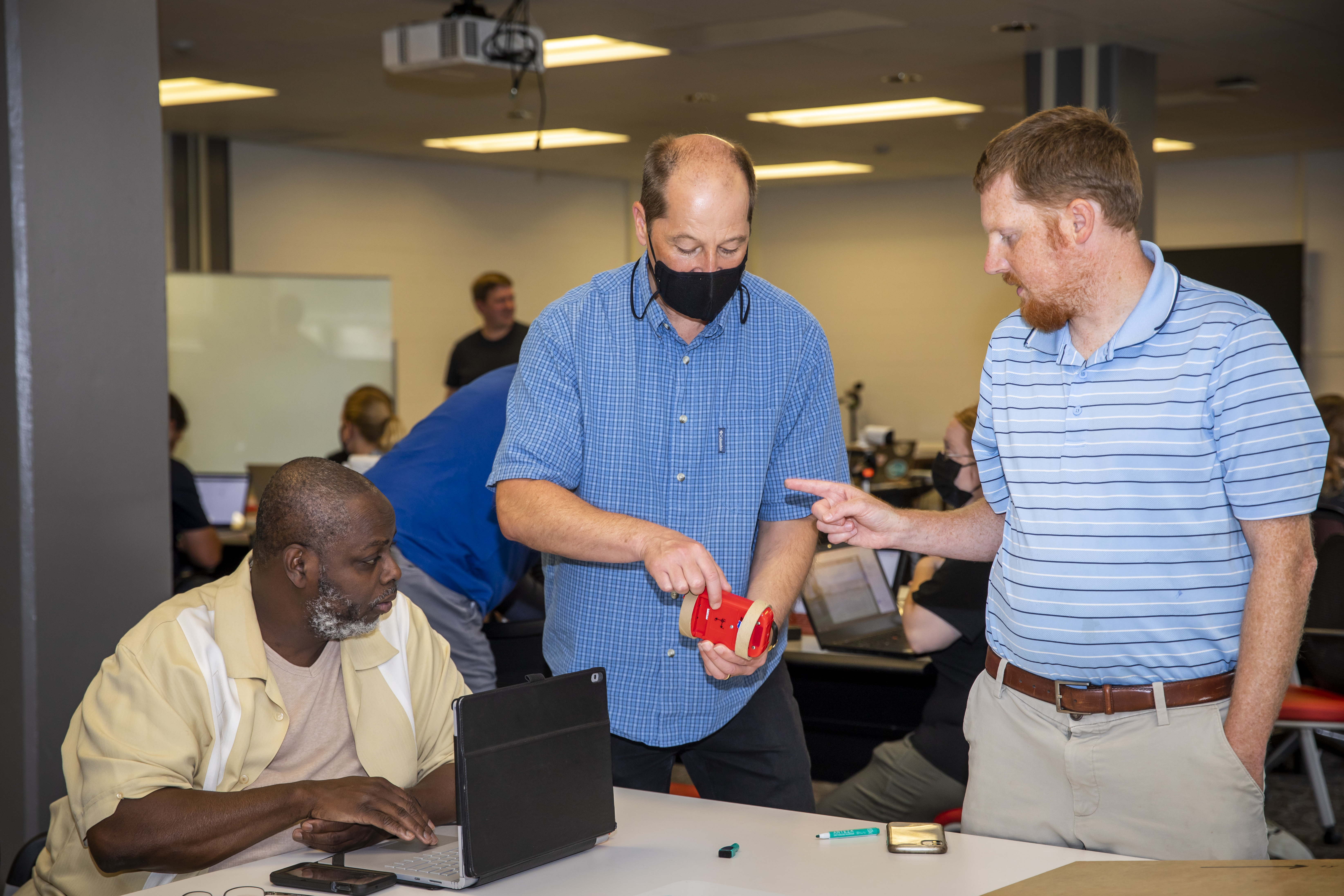 IPaSS PI and Illinois Physics Professor Tim Stelzer (middle) works with IPaSS teaching fellows J. Derrick Conner (left) and Bill Coyle on a rotation iOLab activity. Photo by Michelle Hassel, University of Illinois Urana-Champaign&nbsp;