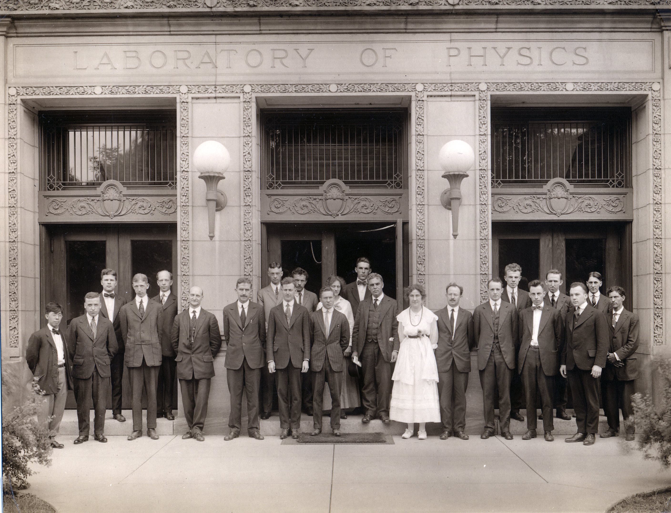 Members of the Department of Physics at Illinois circa 1915/16. Physics alumna Eleanor Frances Seiler, the department&rsquo;s first woman PhD graduate (1922), stands in the fron row in a white dress. Just behind her to the viewer&rsquo;s left is Head of Department Albert P. Carman and next to him, department secretary Della M. Rogers (then the only other woman in the department). Photo credit Illinois Physics, courtesy of AIP Emilio Segr&egrave; Visual Archives